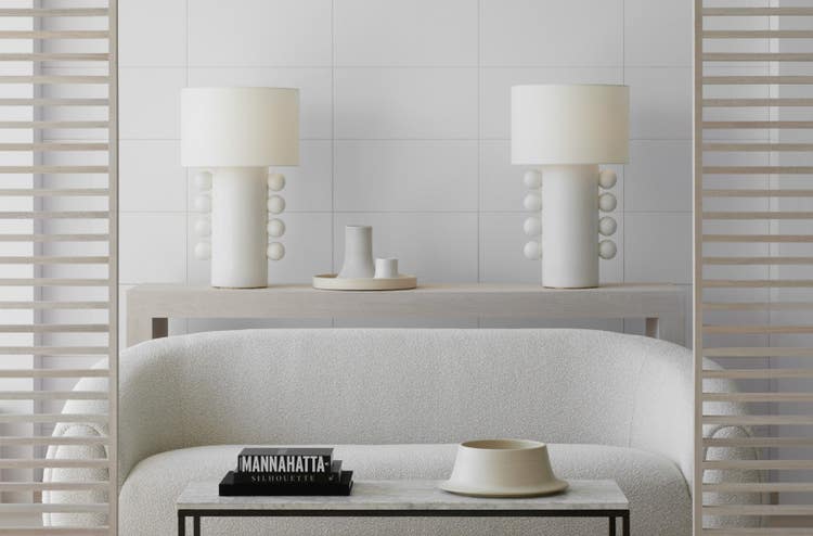 a white table with a white lamp and a white table with a white wall with white tiles